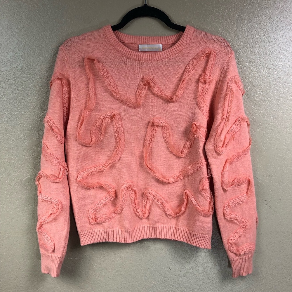 Peach sweater with lace detail.